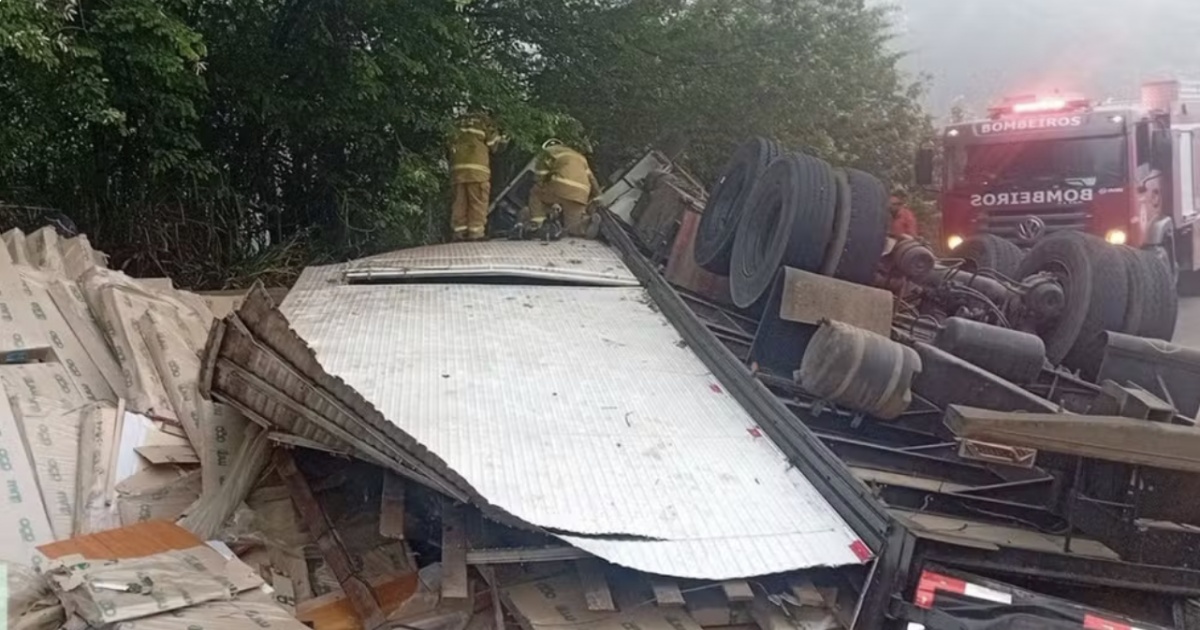Motorista morre após caminhão tombar e espalhar carga de móveis na BR-101, em Itabela